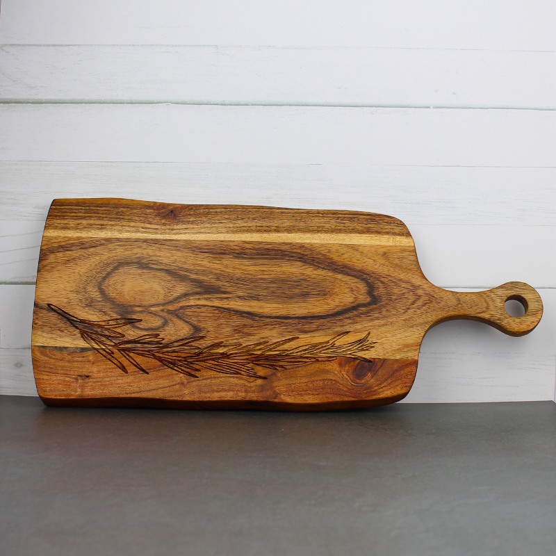 Engraved wooden serving board with rosemary engraved design for charcuterie or desserts.