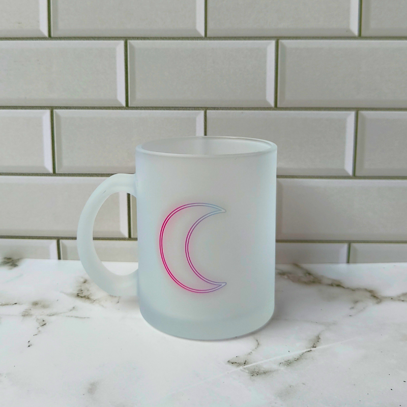 Frosted glass cup with neon crescent moon print.
