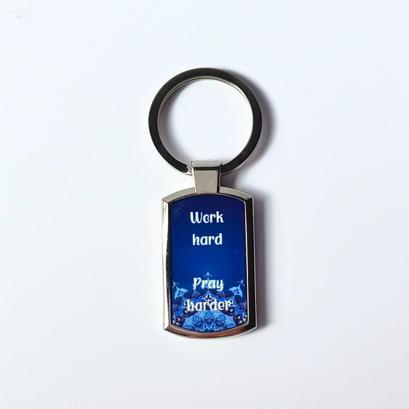 Work hard, pray harder silver finish metal keyring with blue Islamic printed design.