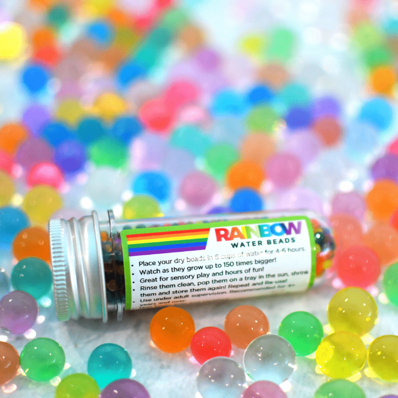 Discover our vibrant rainbow water beads! These reusable and certified water beads provide hours of sensory play. Non-toxic, biodegradable, and safe for kids above 5. Lifestyle image of beads in and out of the container.