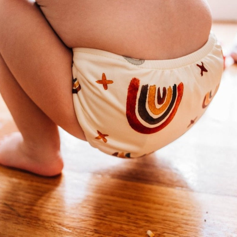 Switch to eco-friendly Modern Cloth Nappies (MCNs) for babies.  Lifestyle image of rainbow earth tones.