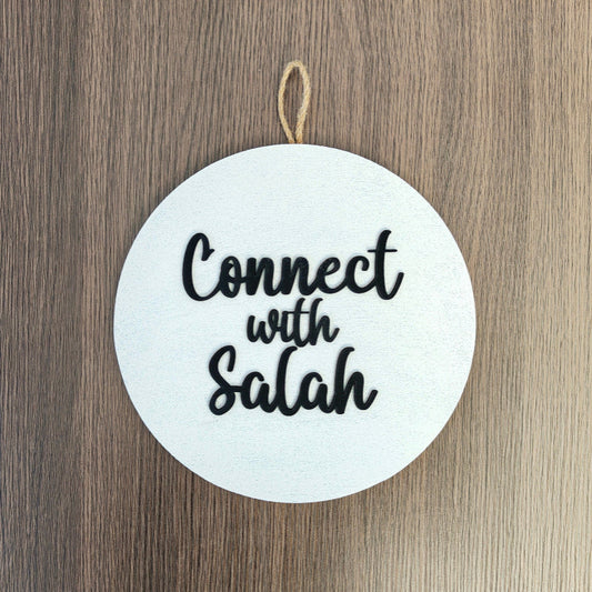 Round white sign with 'Connect with Salah' text on a wooden background