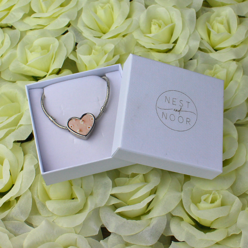 Charm bracelet in white gift box with daisies printed charm.