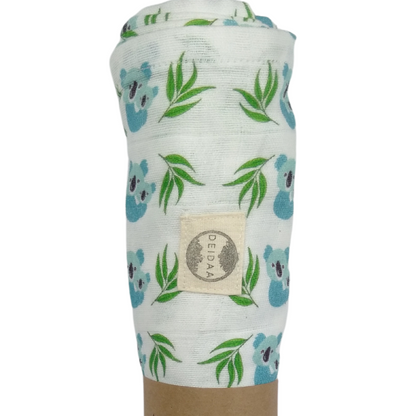 Wrap your baby in pure comfort with our GOTS certified organic cotton muslin swaddle. Ethically made and toxin-free, our breathable swaddle is perfect for newborns. Koala design on white background.