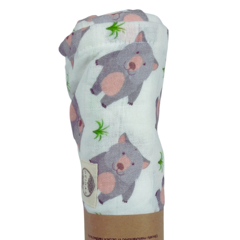 Wrap your baby in pure comfort with our GOTS certified organic cotton muslin swaddle. Ethically made and toxin-free, our breathable swaddle is perfect for newborns. Wombat design on white background.