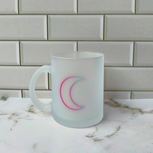 Frosted glass cup with neon crescent moon print.