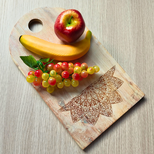 Wooden cutting board with fruit and mandala design on a light wooden surface