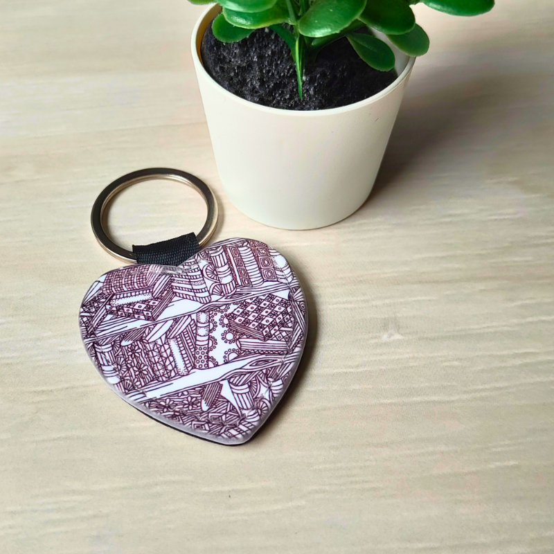 Vegan leather heart-shaped keyring with bookshelf pattern.