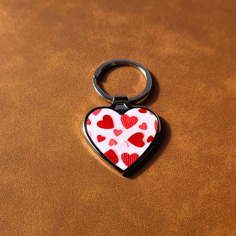 Heart-shaped metal keyring with heart candy print.