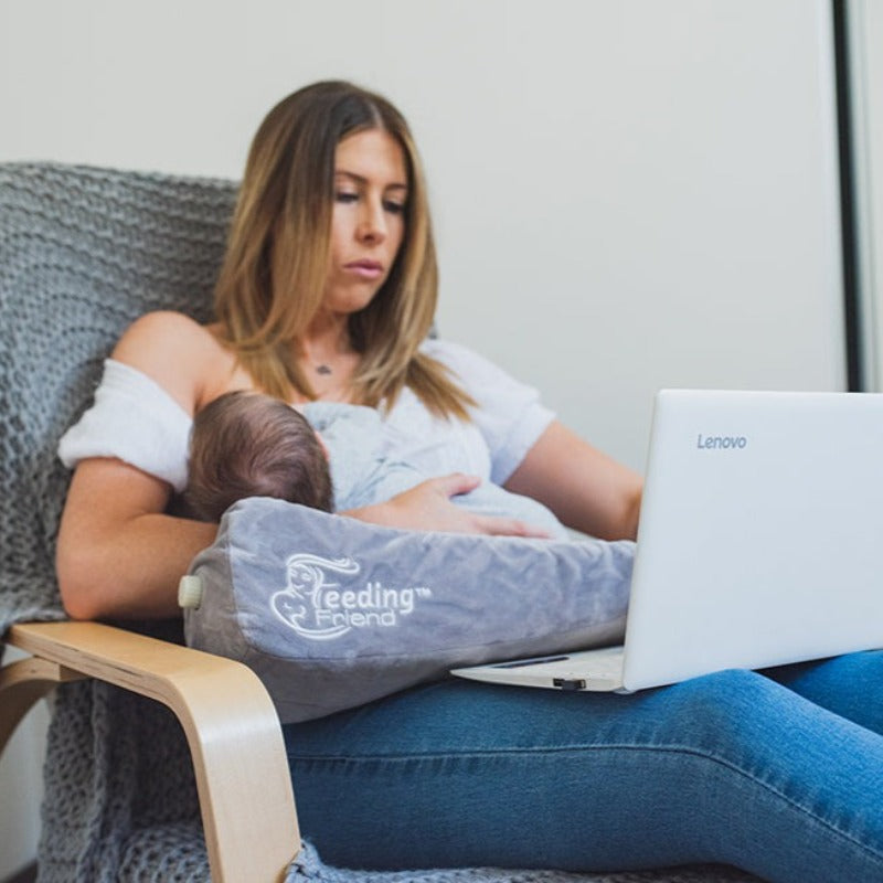 Feeding Friend Nursing Pillow - The Perfect Gift for Hassle-Free Baby Feeding. Woman breastfeeding while working on computer.