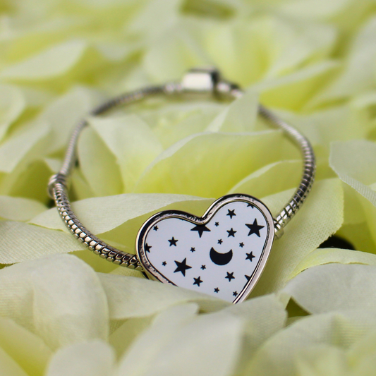 Silver charm bracelet with black and white stars and moon printed heart-shaped charm.