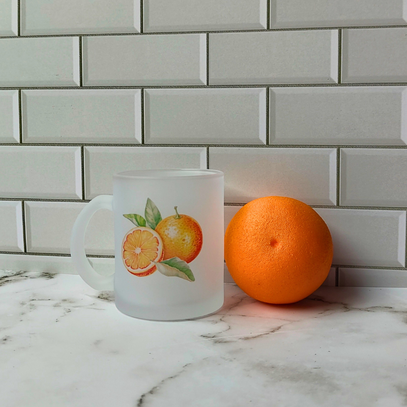 Frosted glass cup wit orange printed design.