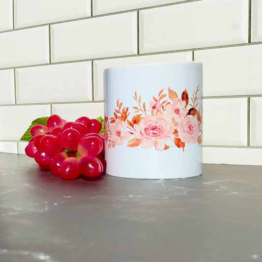 Ceramic coffee cup with pink flowers wrap around design.