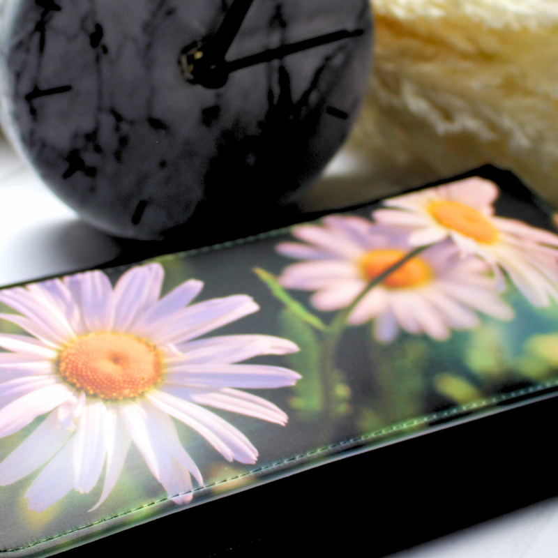 Vegan leather purse with daisy print with clock and plant background