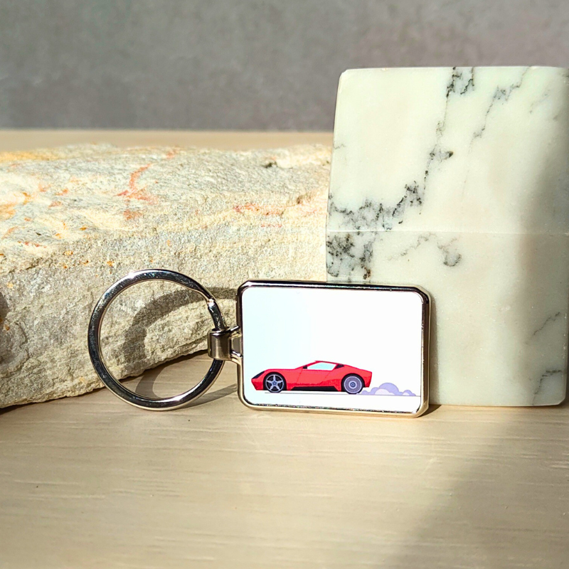 Metal rectangle keyring with cartoon racecar print.