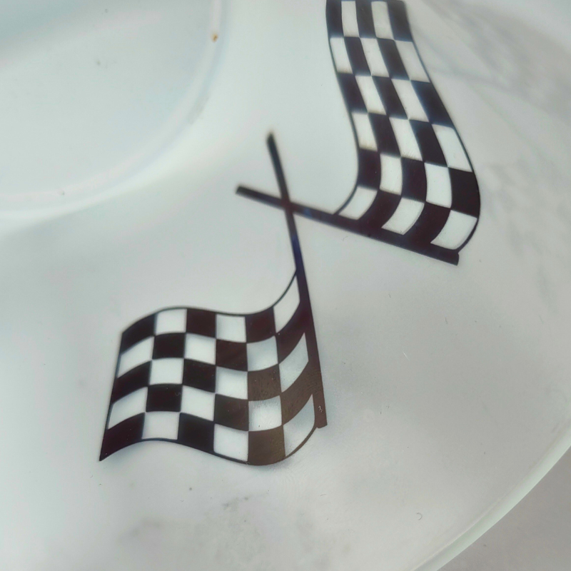 Frosted glass cup with checkered flags design.