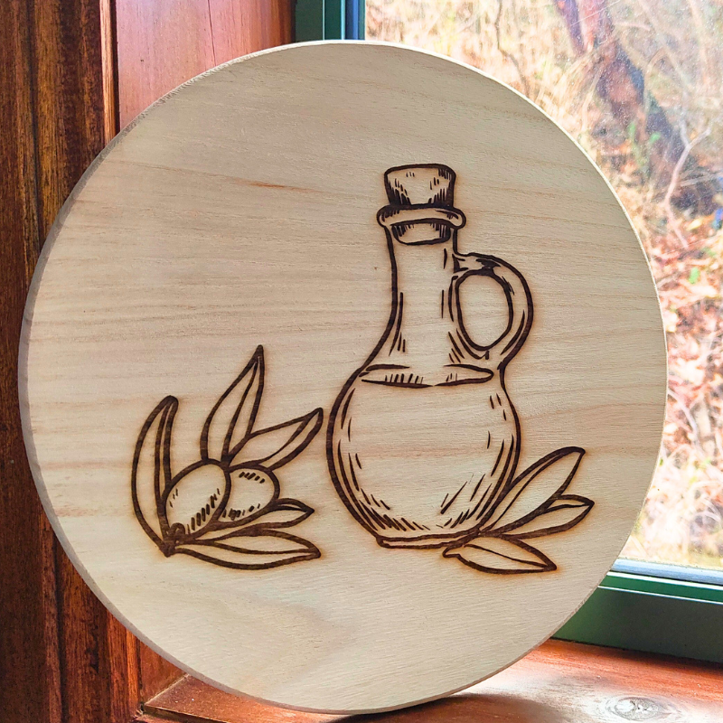 Round wooden decorative plaque with laser engraved olives and olive oil bottle design. Handmade in Australia.
