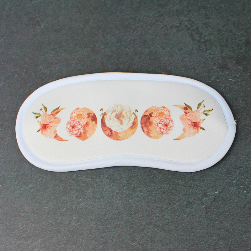 Flowery moon phases sleeping travel eye mask. The perfect travel accessory.