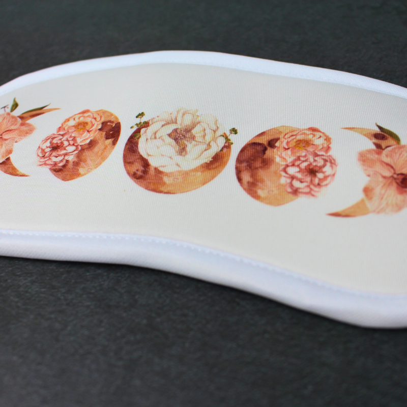 Sleeping eye mask with floral moon phases print.