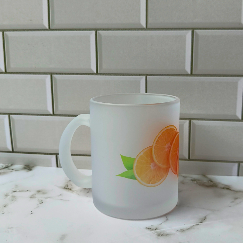 Frosted glass cup with whole sliced orange design.