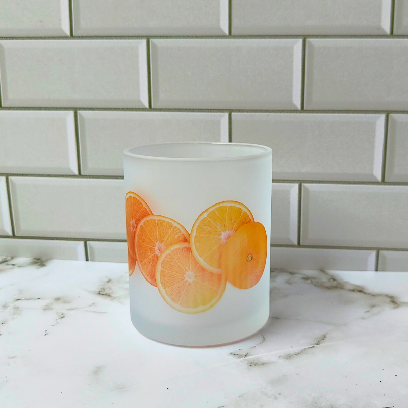 Frosted glass cup with sliced orange design.