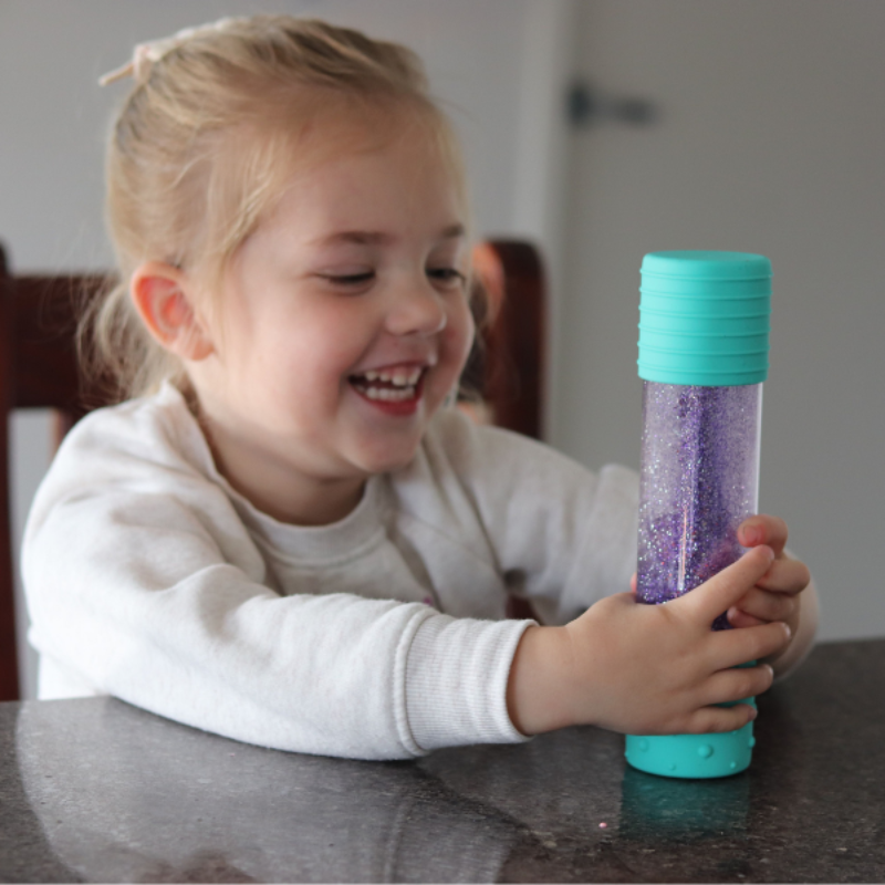 Elevate play with our DIY Sensory Bottle Kit. Small girl playing with sensory bottle