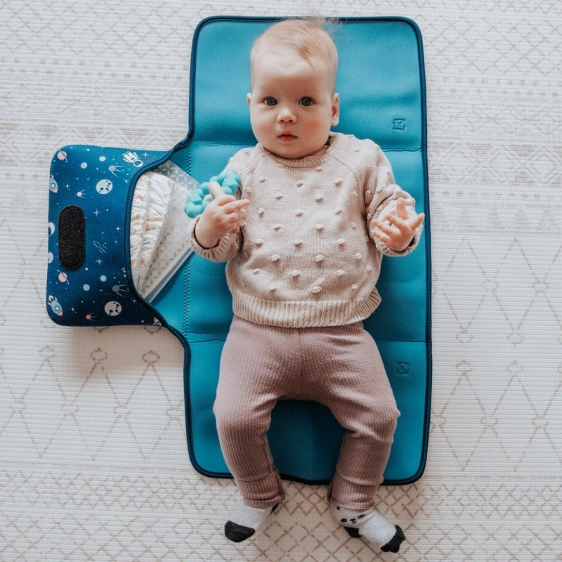 Discover convenience with our Water-Resistant Neoprene Change Mat Clutch. Baby laying on open space design clutch