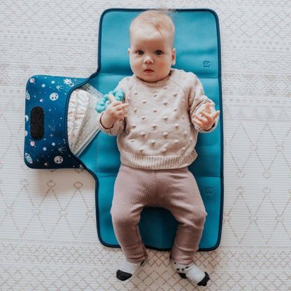 Discover convenience with our Water-Resistant Neoprene Change Mat Clutch. Baby laying on open space design clutch