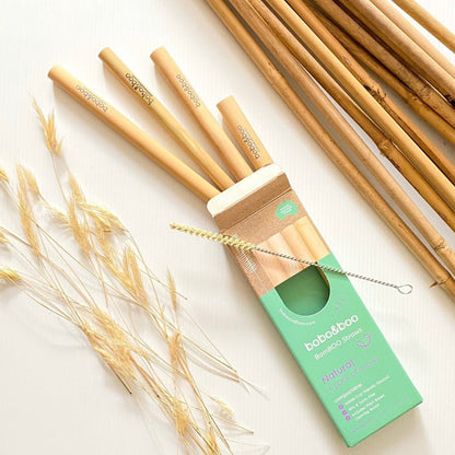 BamBOO Reusable Straws, 4 pack displayed with free straw cleaner next to packaging box, displayed next to bamboo sticks.