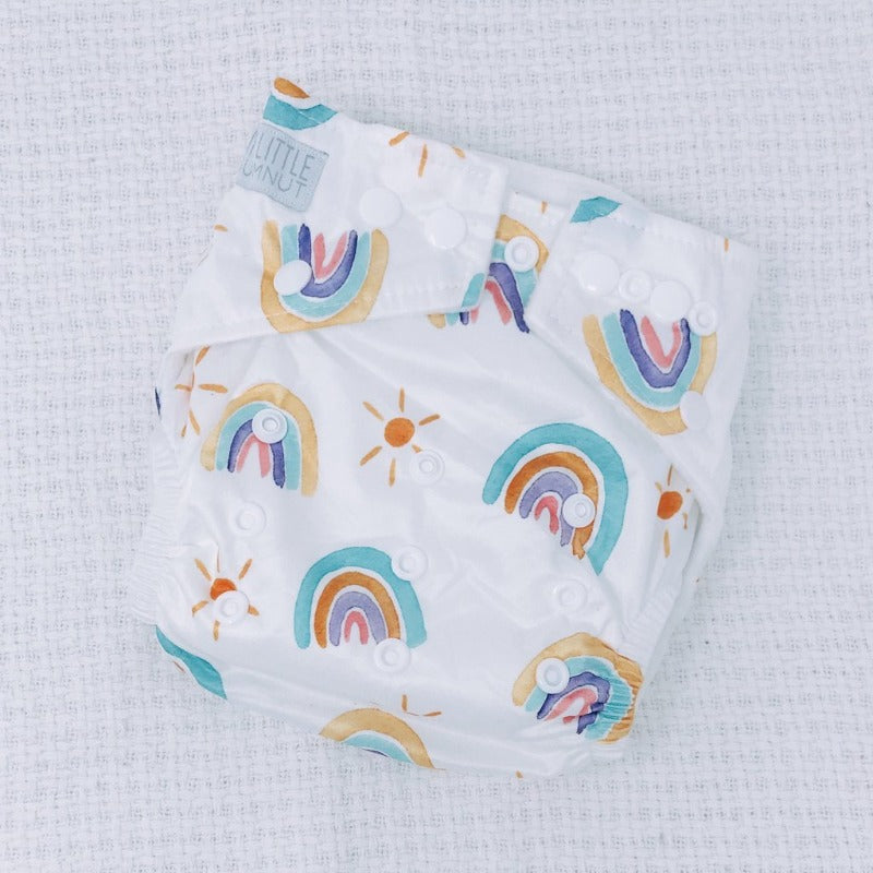 Switch to eco-friendly Modern Cloth Nappies (MCNs) for babies. Pastel rainbow design.