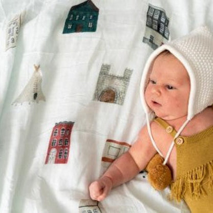 Discover our collection of gorgeous 100% organic cotton muslin swaddles that are lightweight, breathable, and machine washable. Baby laying on ole houses design swaddle.